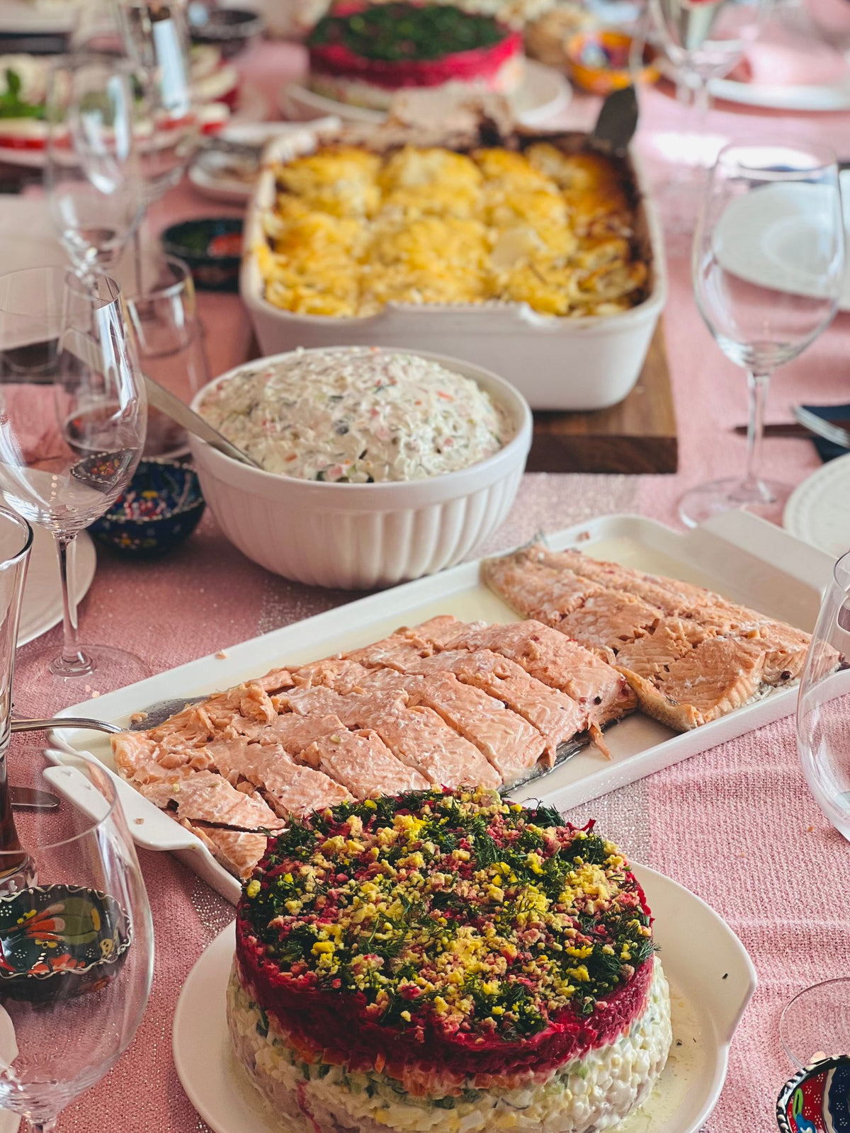 Festive dining table set with a meal and glasses of red wine