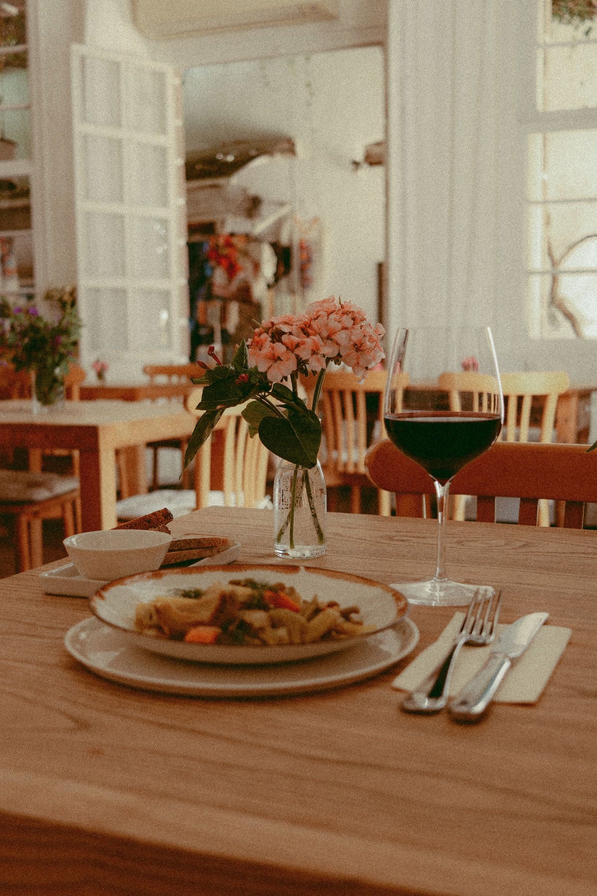 Glass of red wine served alongside a meal at a set restaurant table