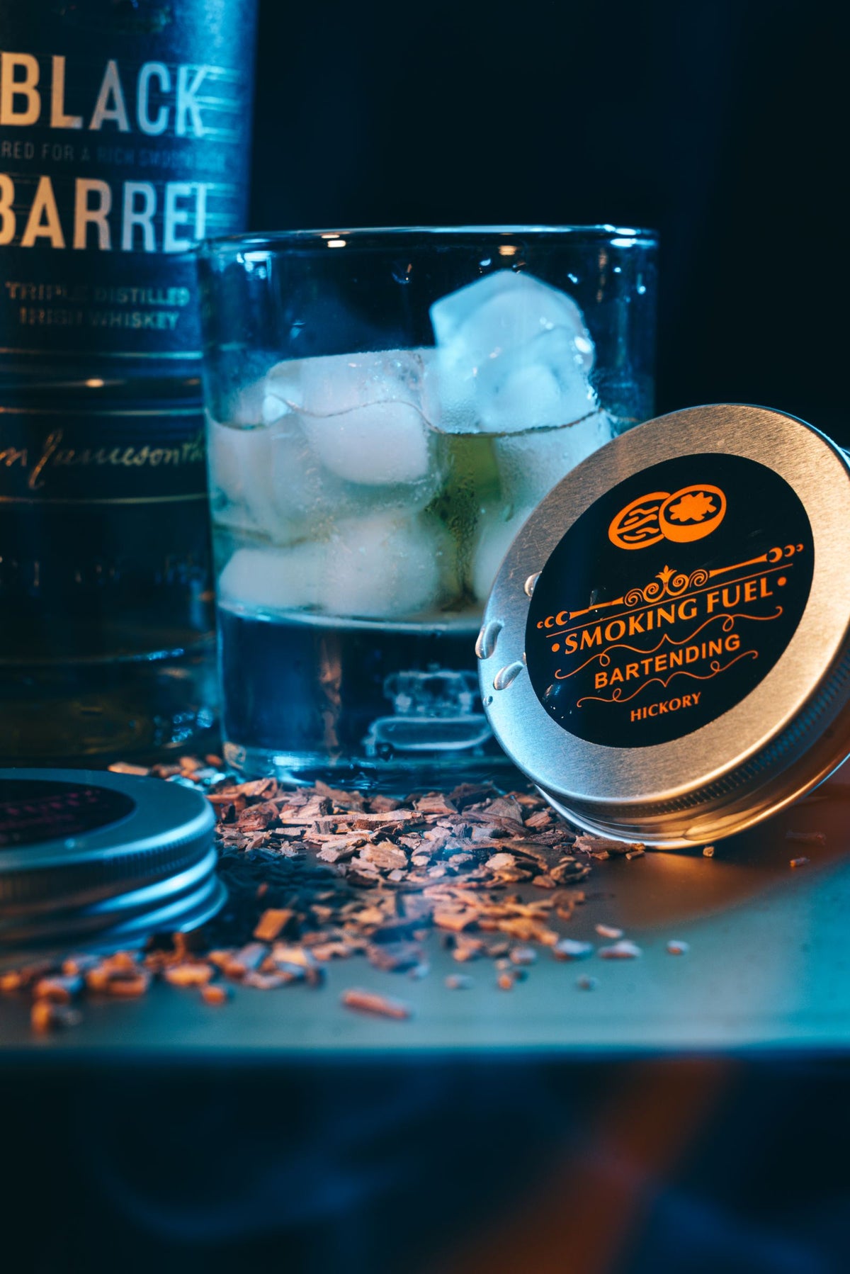 Smoky whiskey glass with ice cubes in a moody bar setting