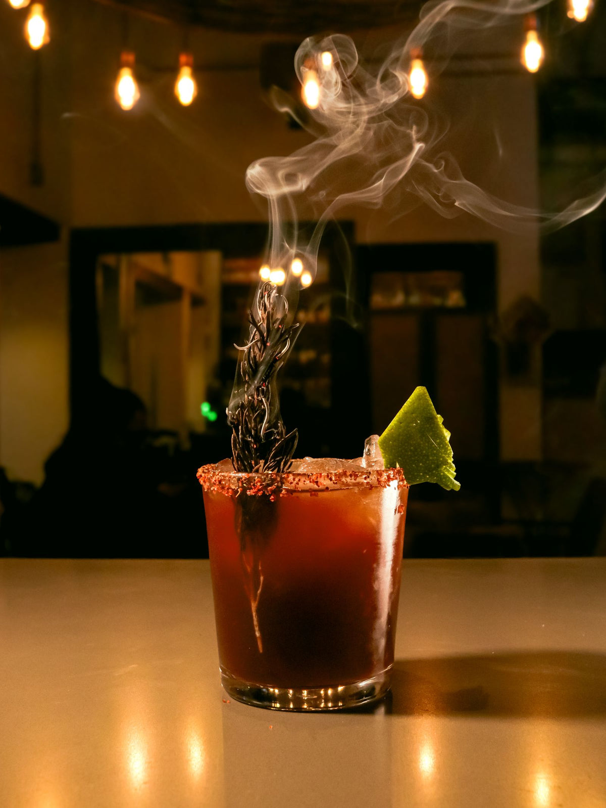 Smoky mezcal cocktail with a lime wedge and black salt rim