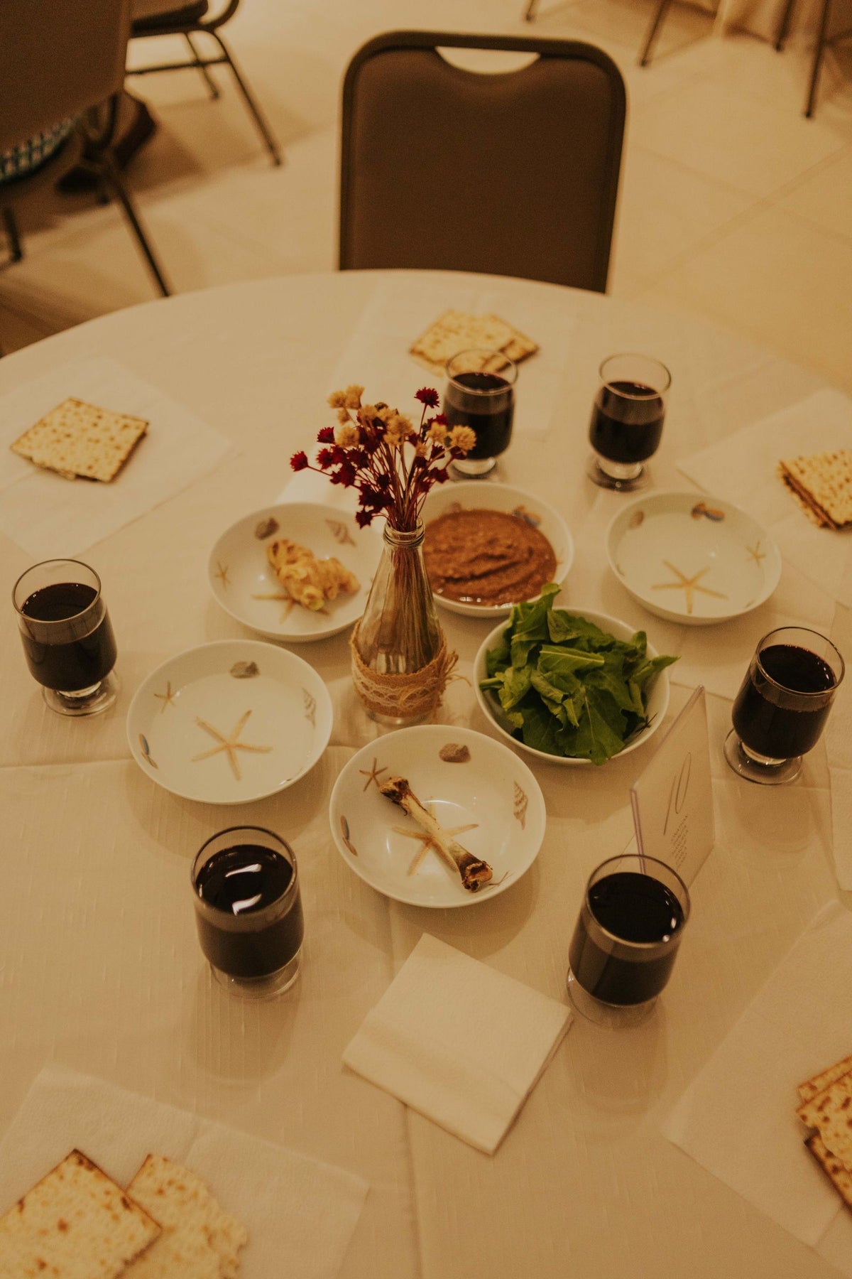 A beautifully set Passover Seder table with matzah and wine cups