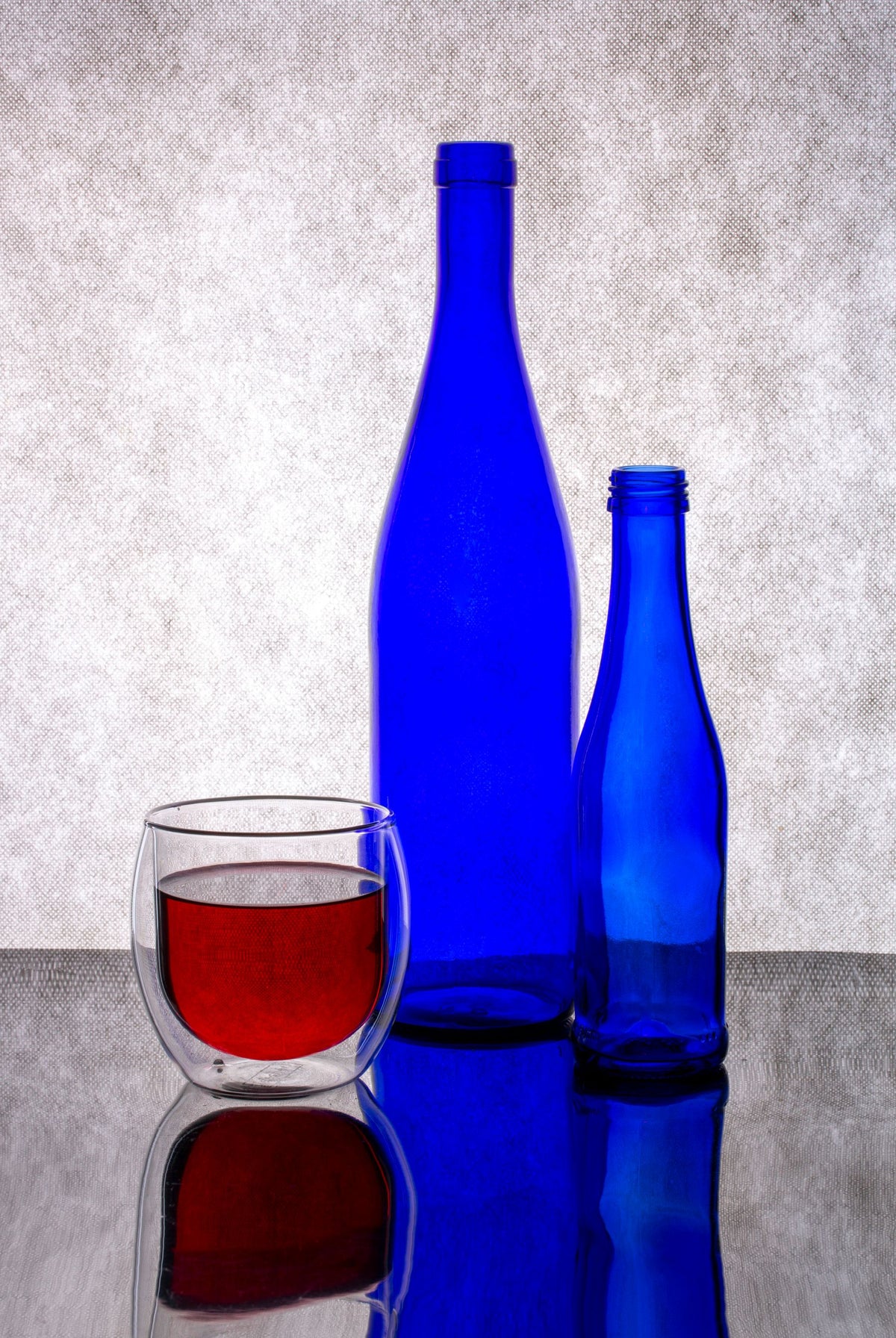 Blue glass bottles catching the light on a dark surface