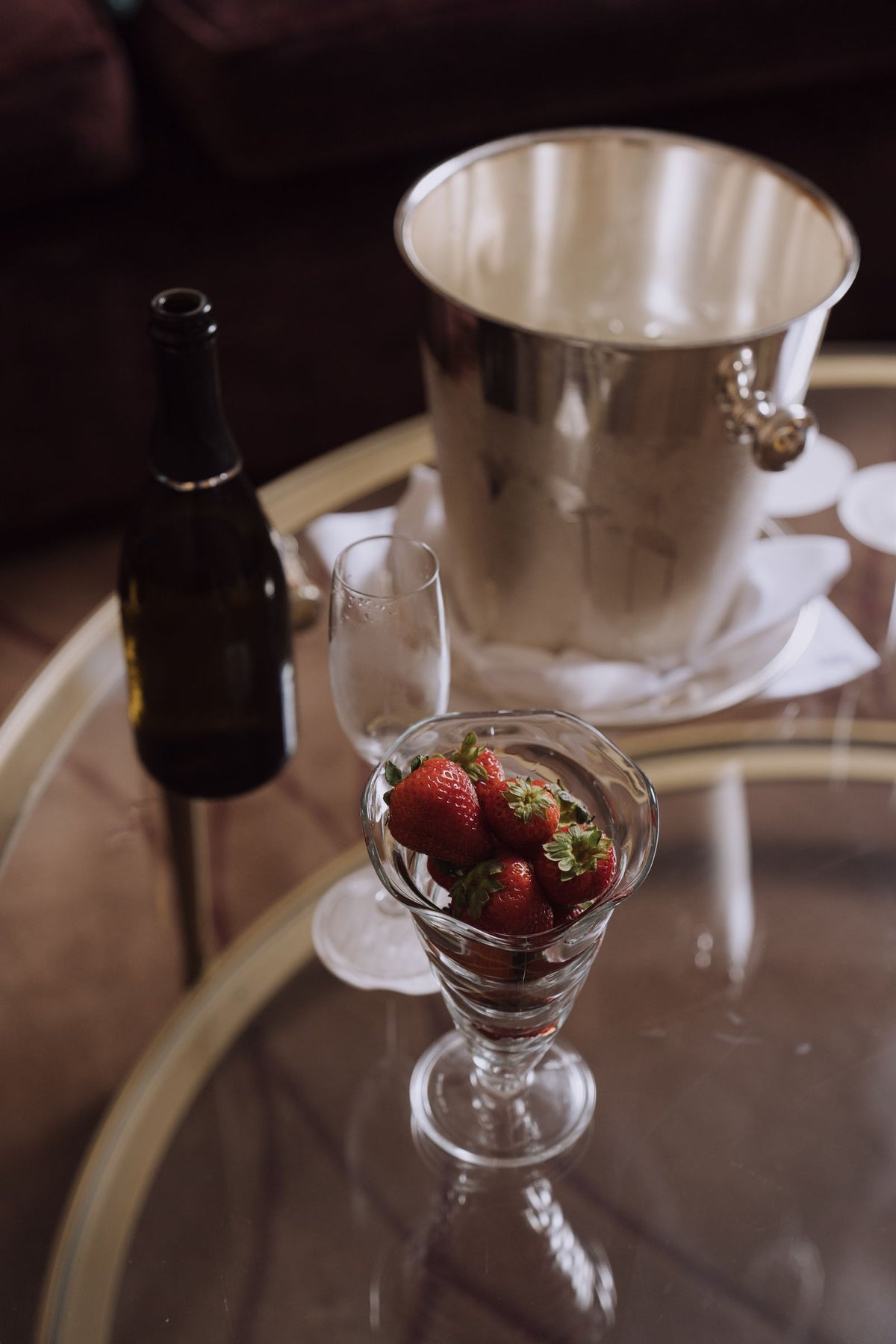 A glass of red wine beside fresh strawberries, styled as a dessert pairing
