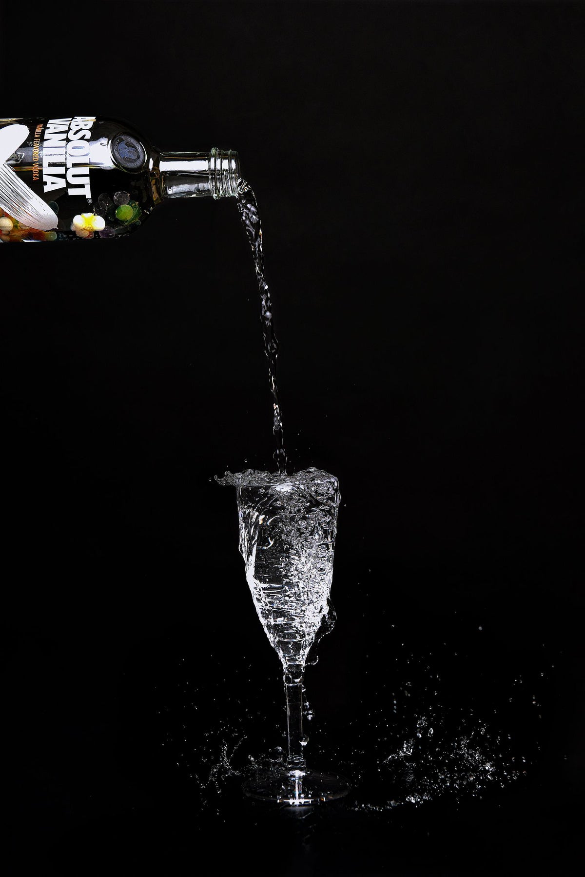 Clear high-proof spirit splashing into a glass