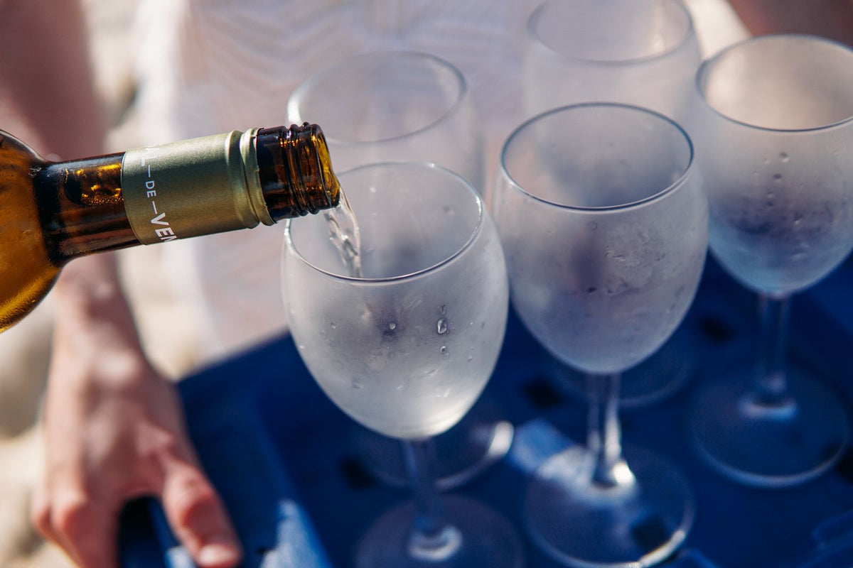 Chilled white wine being poured into a frosted glass