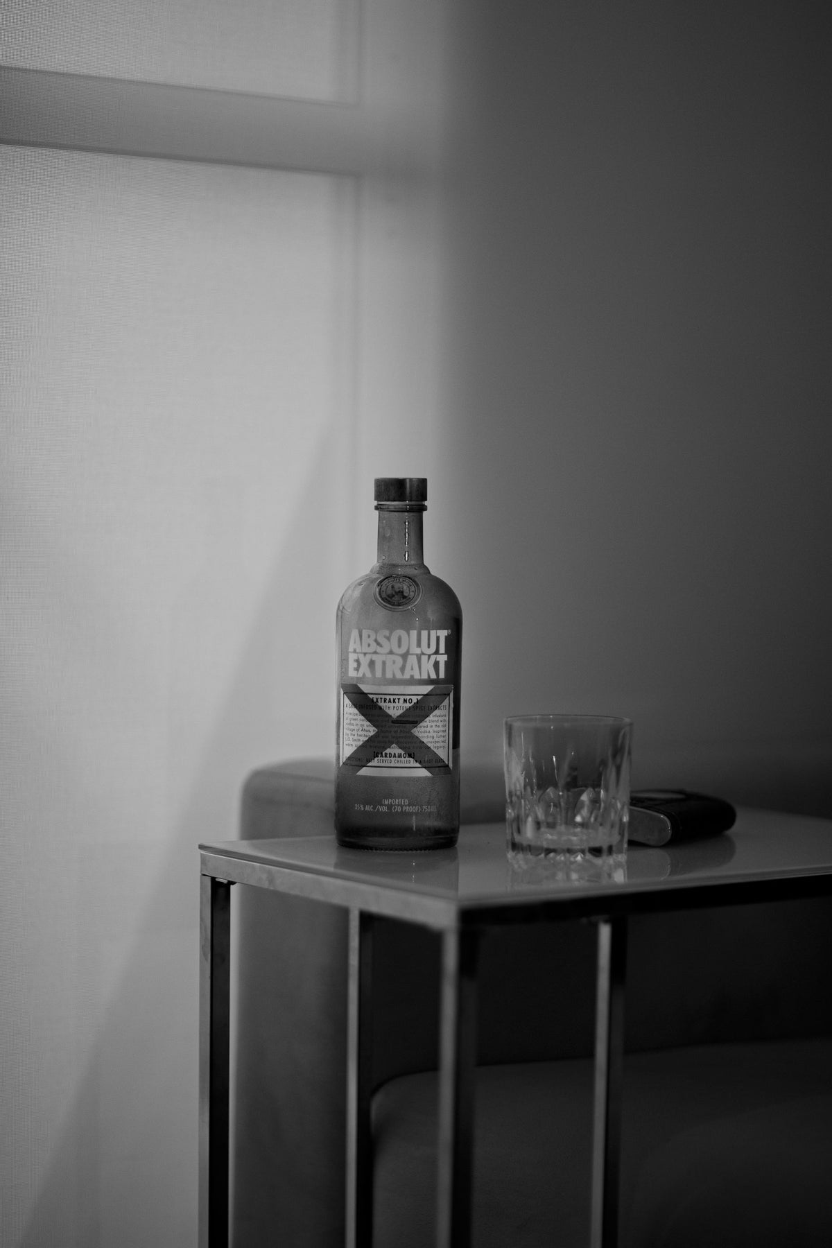 A frosted clear spirit bottle standing on a metal table