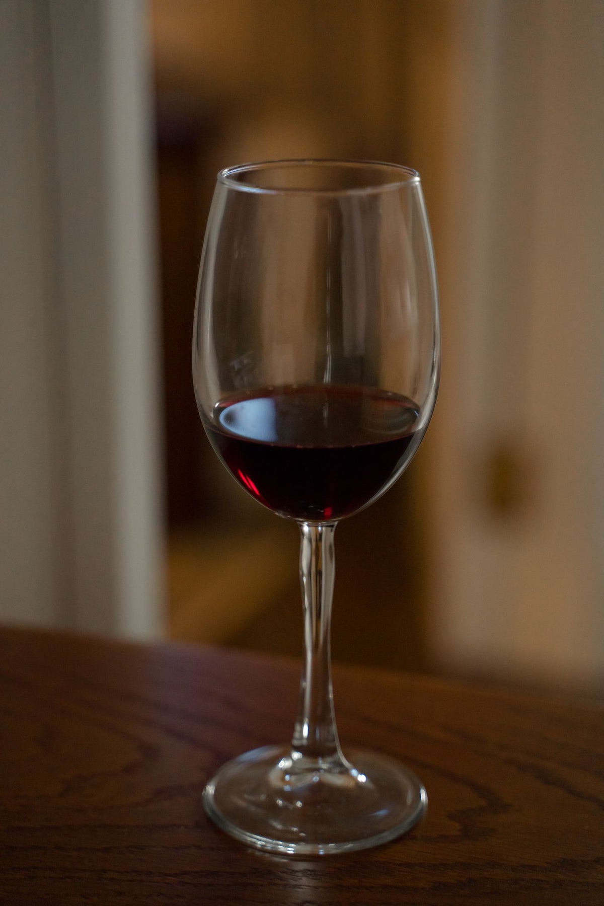 A partly filled glass of red wine resting on a table