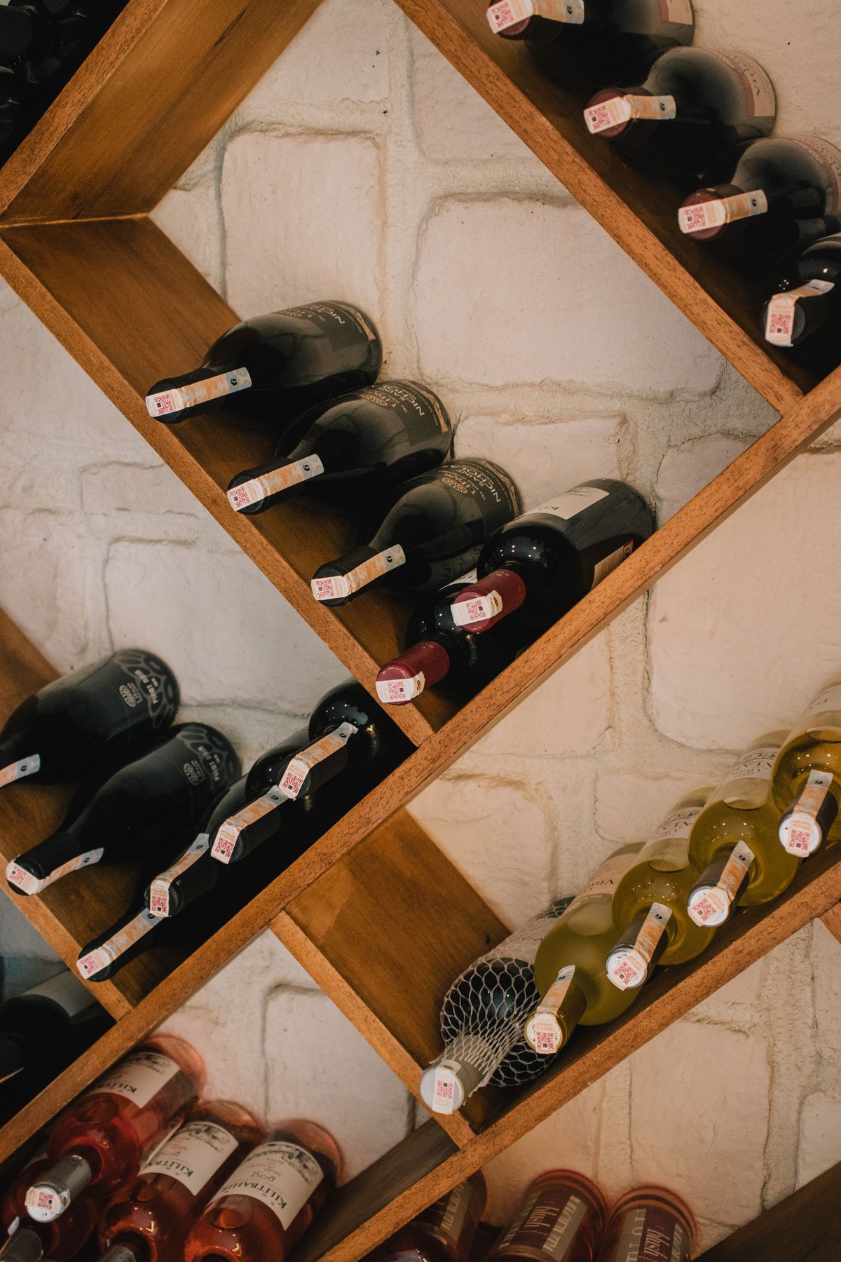 Red, white and rose bottles stored on a diagonal wine rack