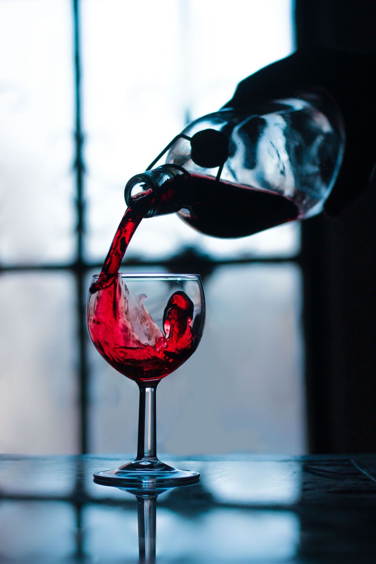 Close-up shot of red wine being poured into a glass