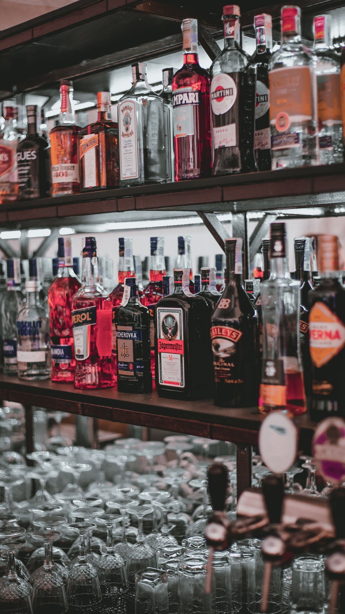 A long bar shelf lined with bottles of spirits