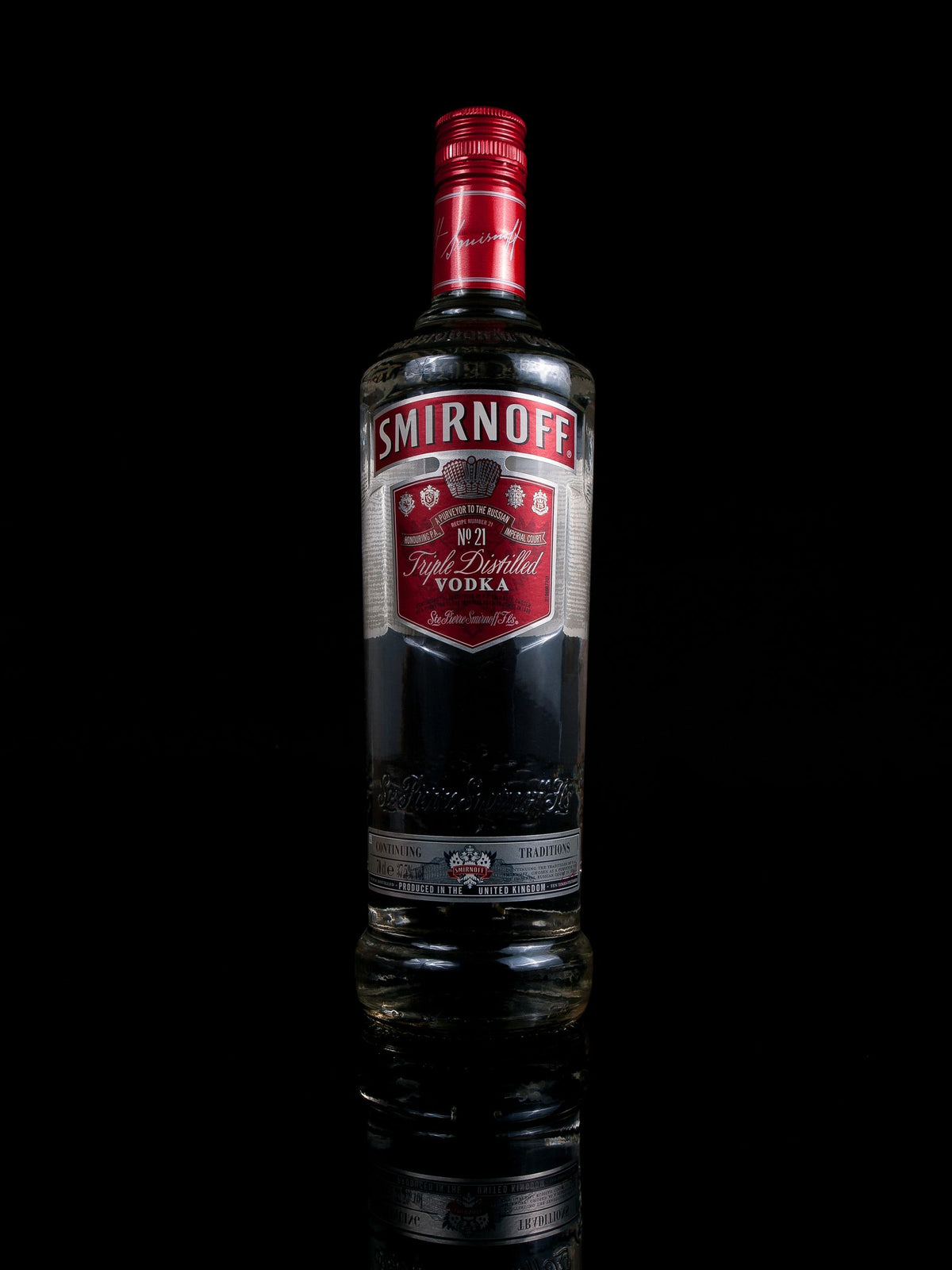 A bottle of Smirnoff vodka reflected on a black surface