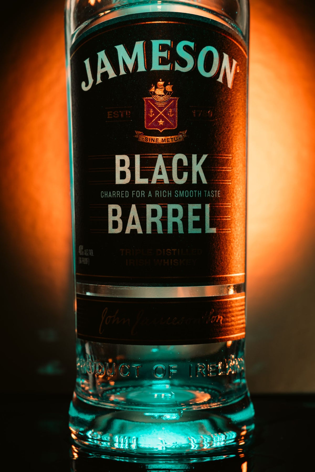 A bottle of Jameson Black Barrel Irish whiskey lit from behind