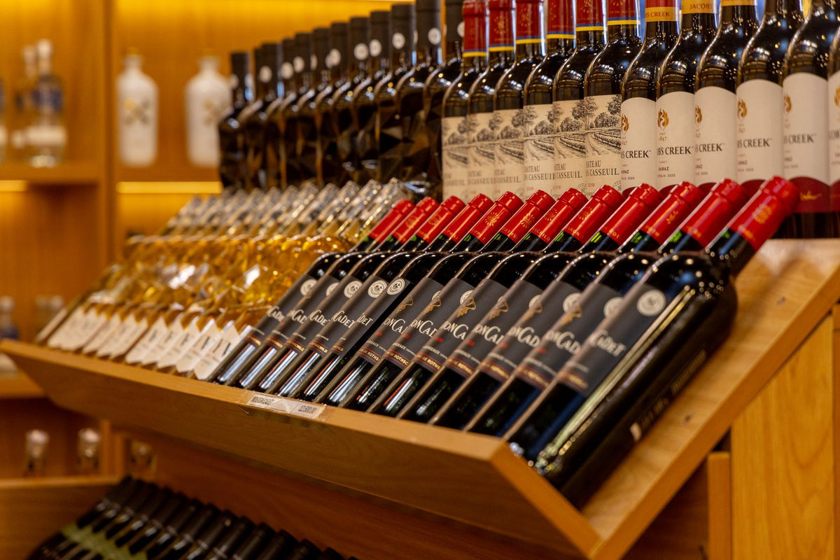 Wine bottles arranged on wooden shelves in a wine shop display