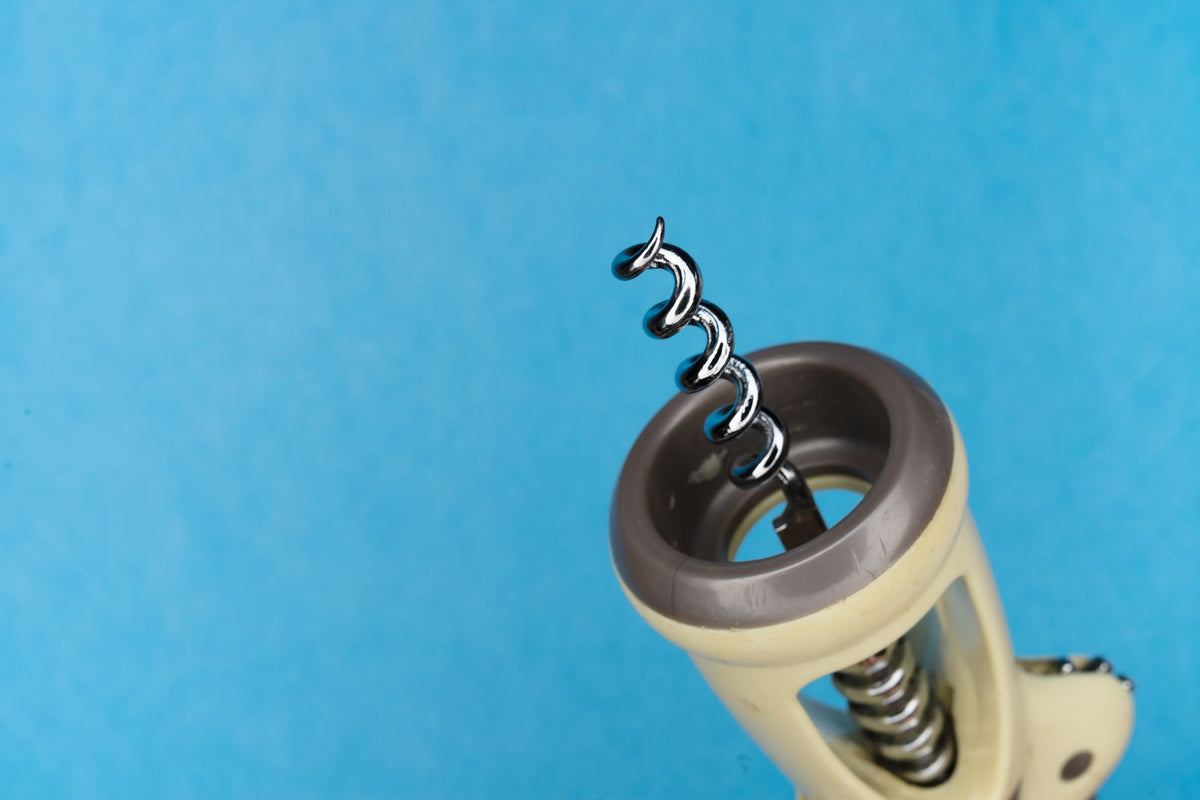 Close-up of a corkscrew against a blue background