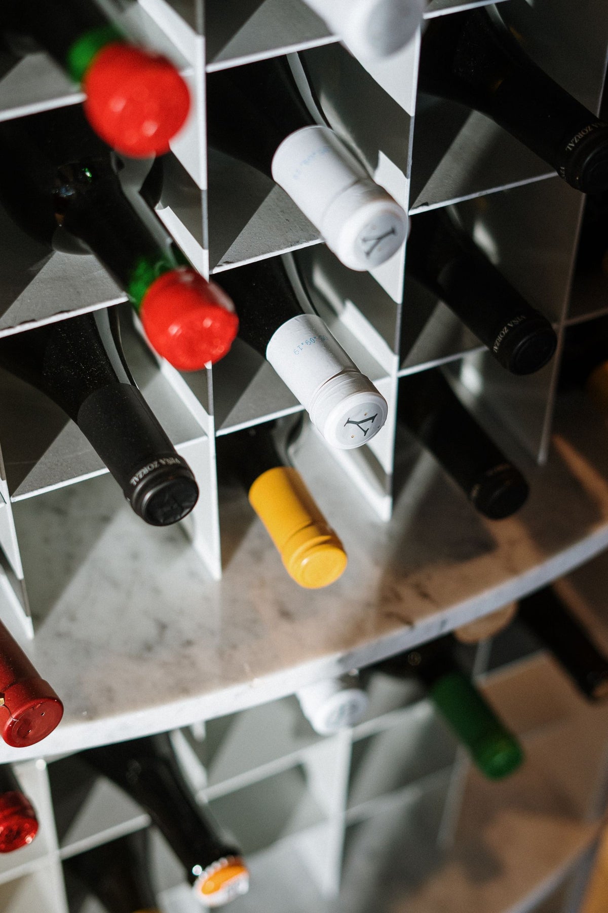 Wine bottles lying on their sides in a white geometric wine rack