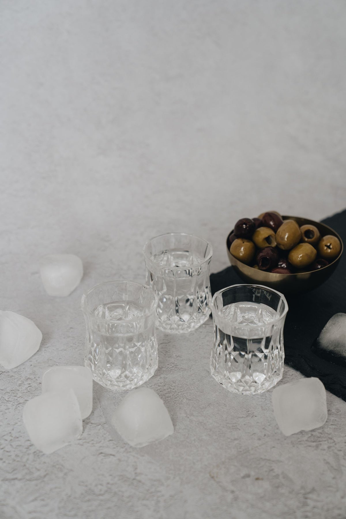 Clear anise spirit over ice with a bowl of olives