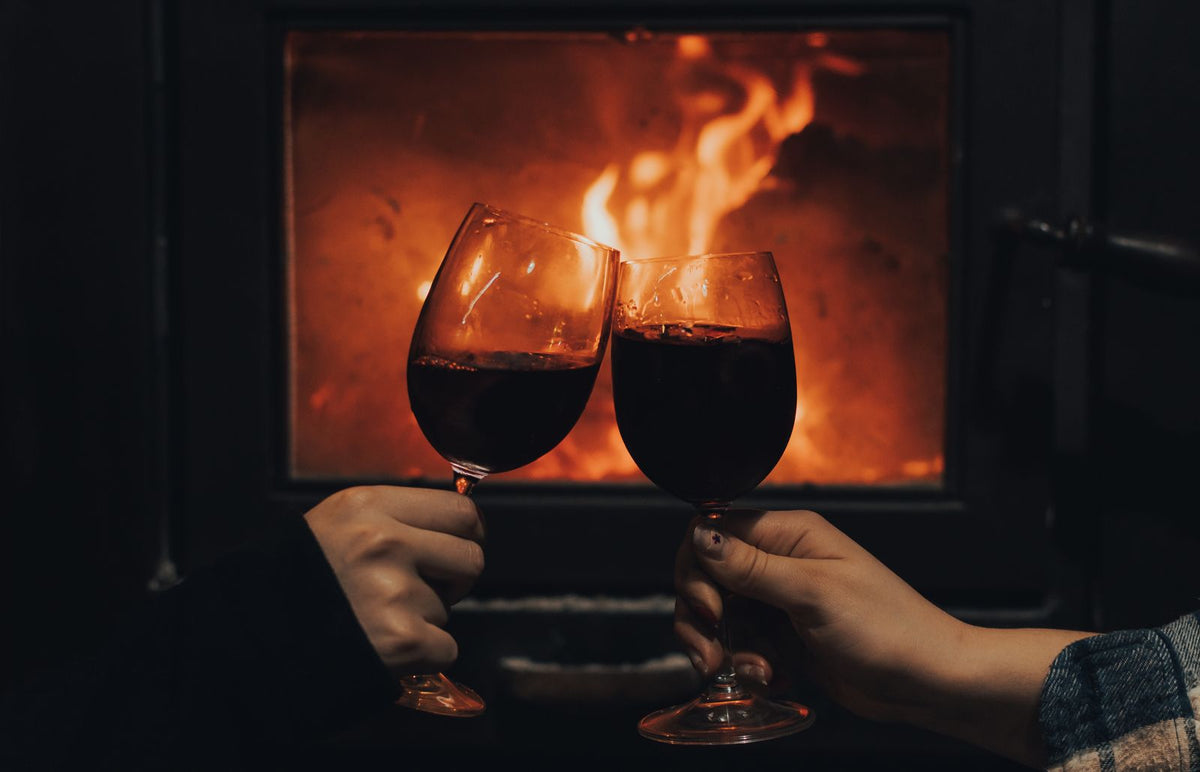 Two people clinking sparkling wine glasses in a close-up toast