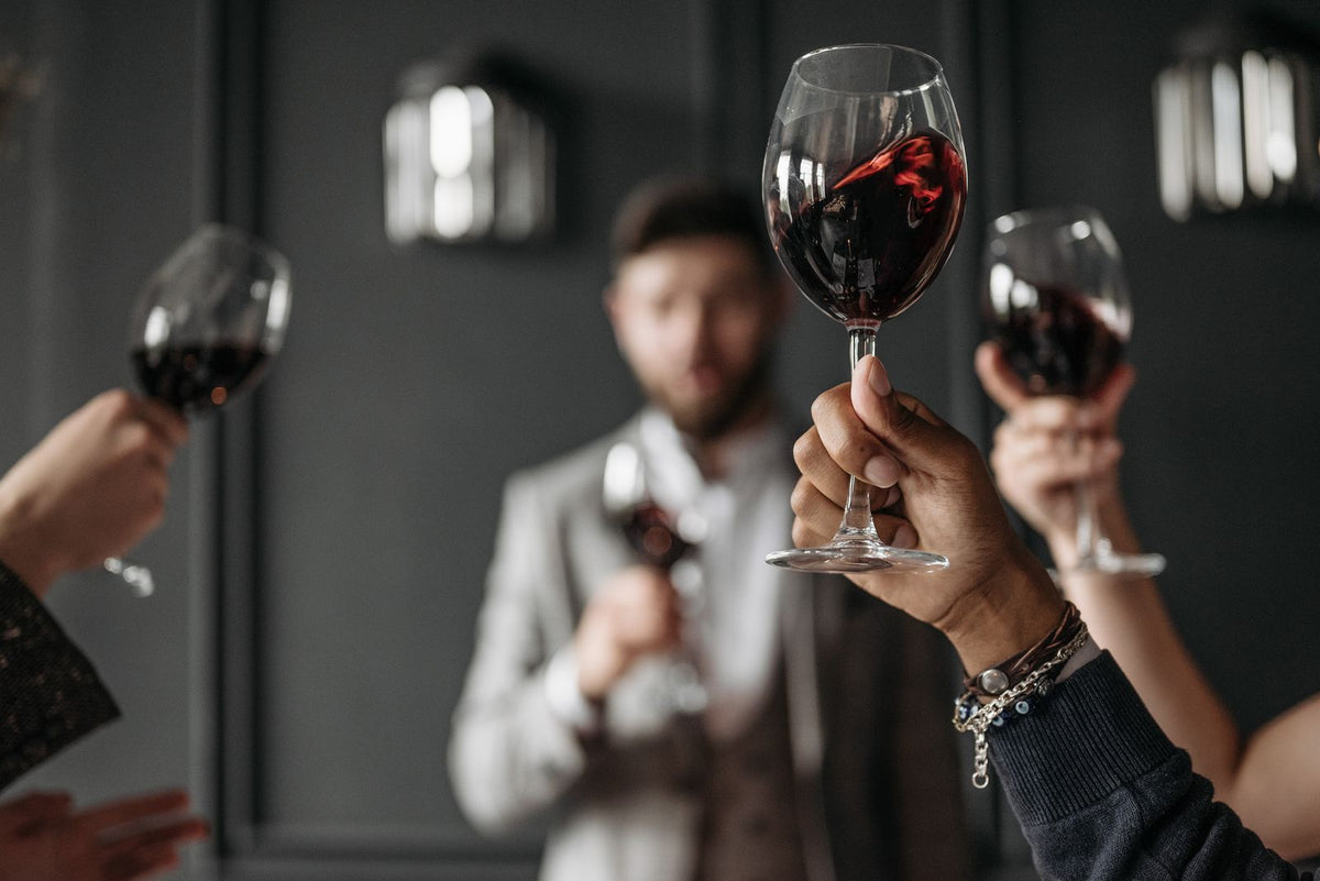 Friends raising glasses of red wine in celebration at a festive gathering