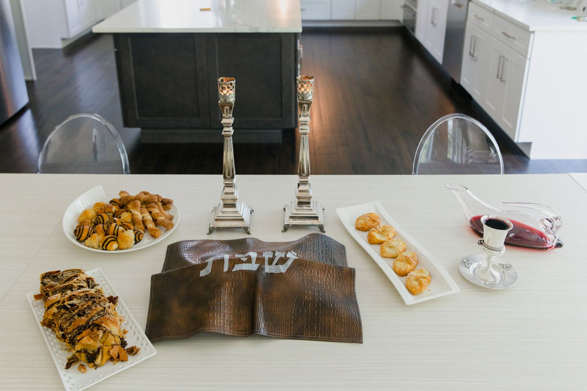 A Shabbos table set with kiddush wine and pastries